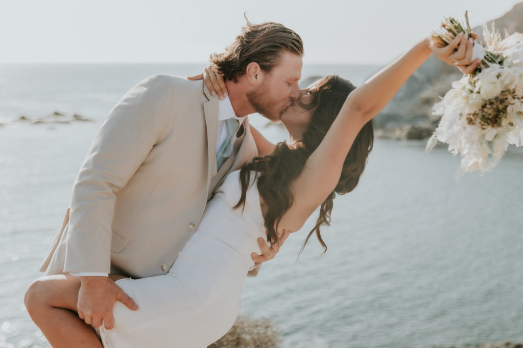 Groom kissing bride while dipping her backwards
