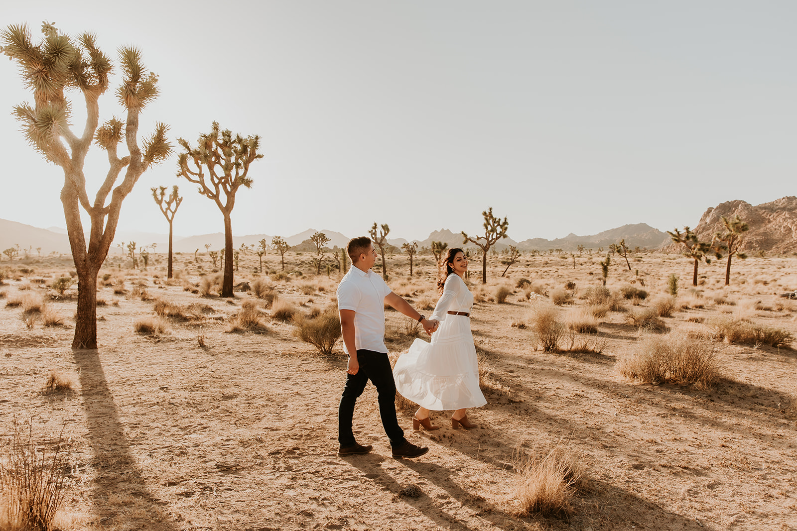 couple walking through the desert in joshua tree