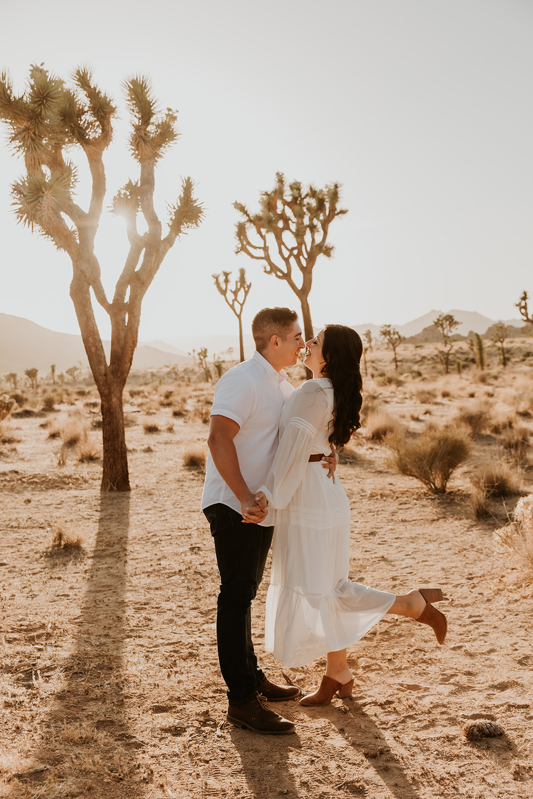 couple kissing in joshua tree during their engagement session