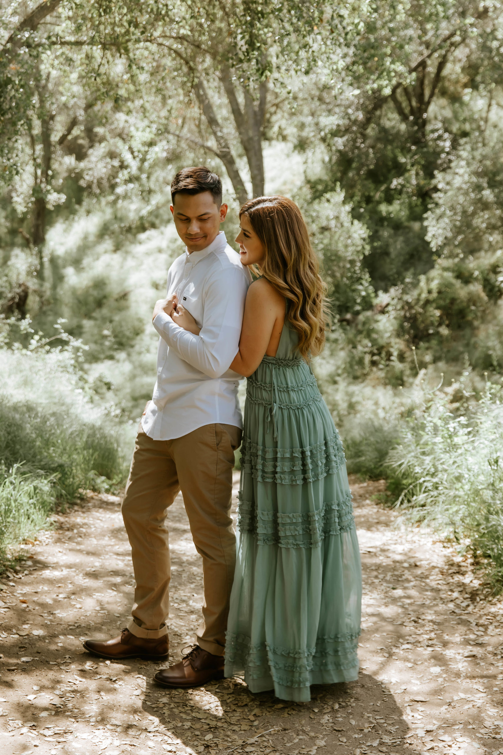 finacee hugging fiance from behind. during their engagement photos