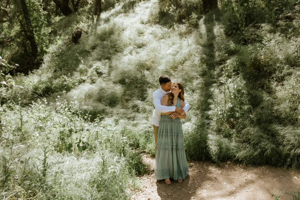 couple hugging in the forest during engagement photos