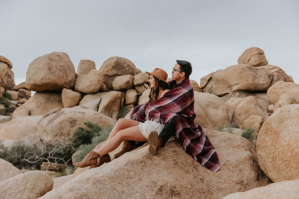 Couple snuggling in blanket during their Joshua Tree Engagement Session