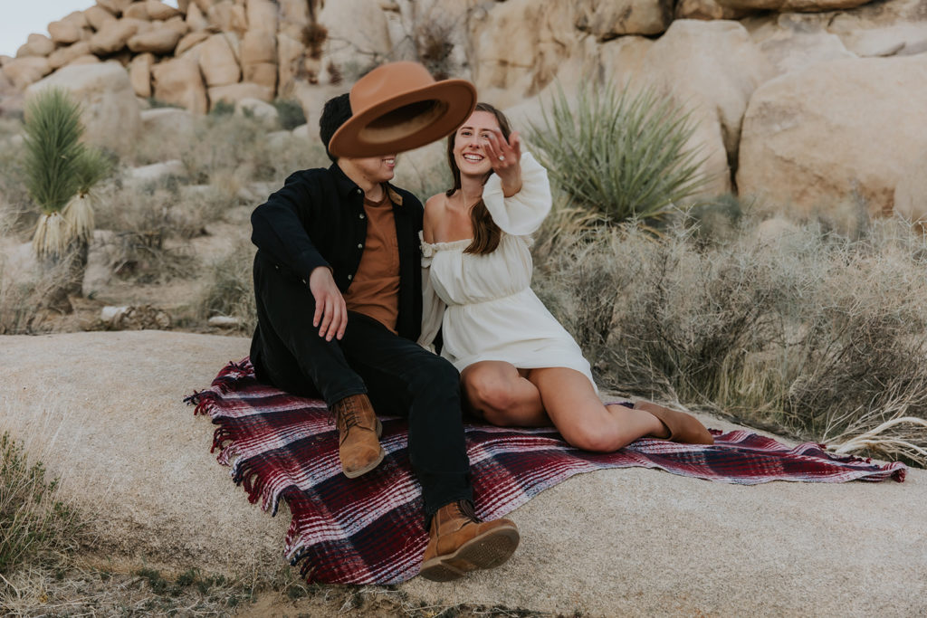 Girl throwing hat towards camera during an engagement session