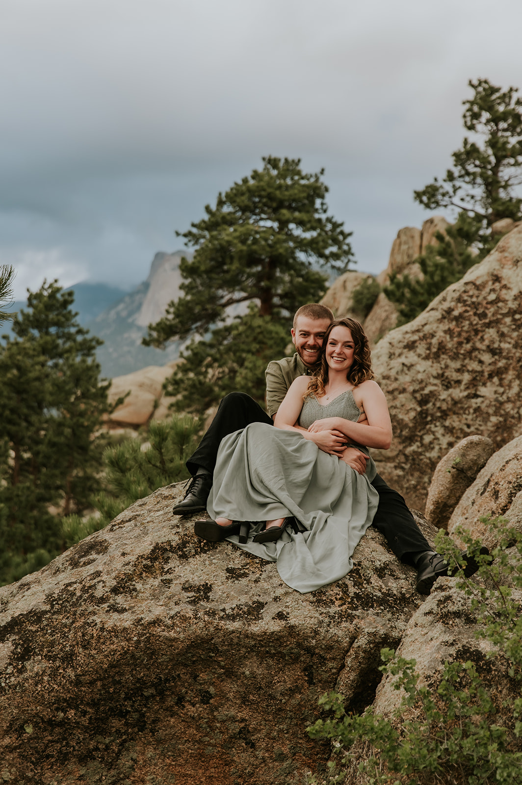 couple sitting on a rock at the stanley hotel in estes park colorado