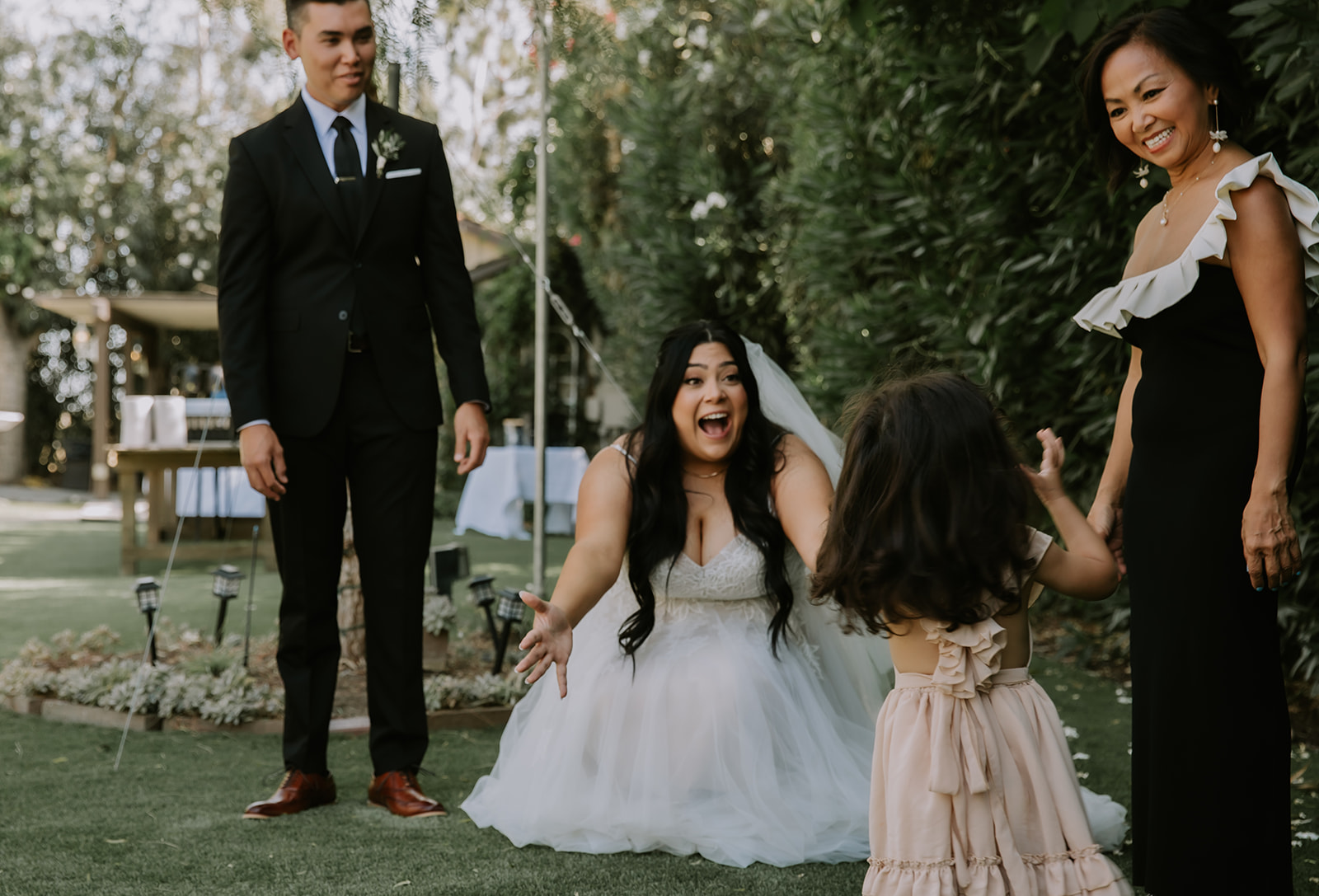 Bride crouched down looking at daughter