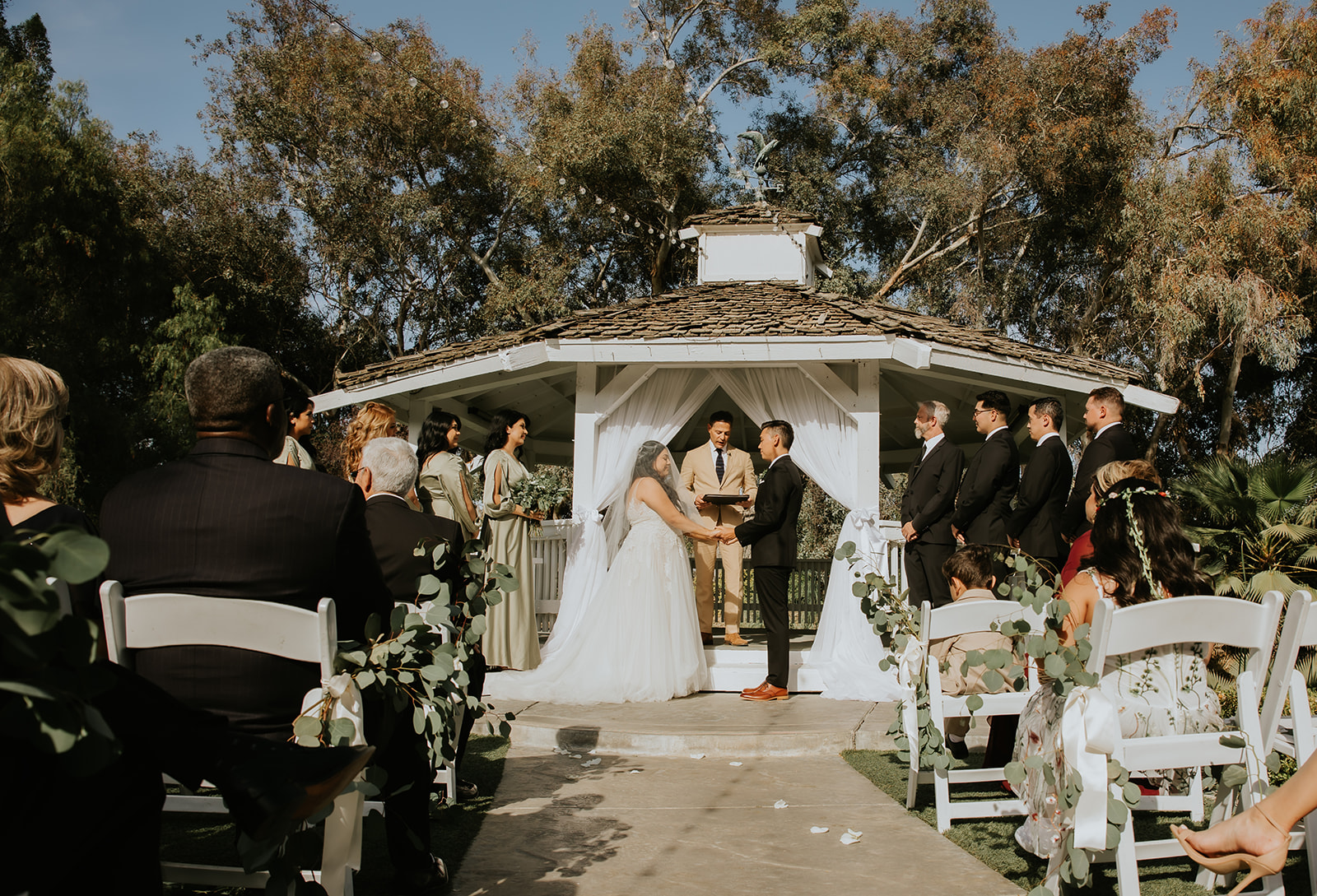 bride and groom holding hands at the alter during their ceremony at The Orchard by Wedgewood Weddings in Menifee California