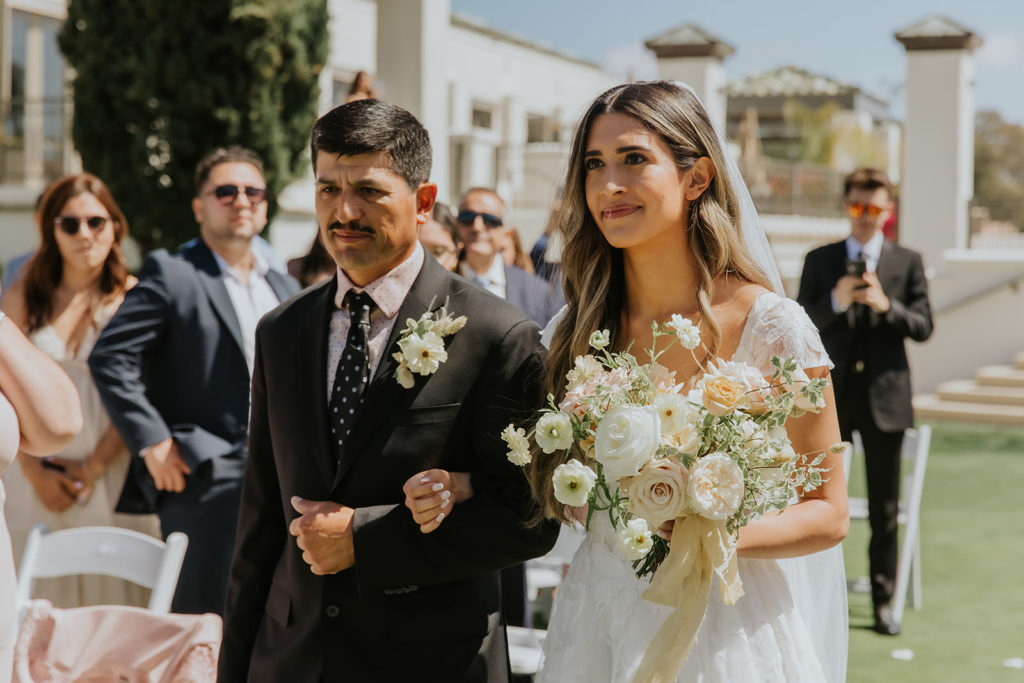 Bride walking down the aisle with her dad at the Marbella Country Club in San Juan Capistrano