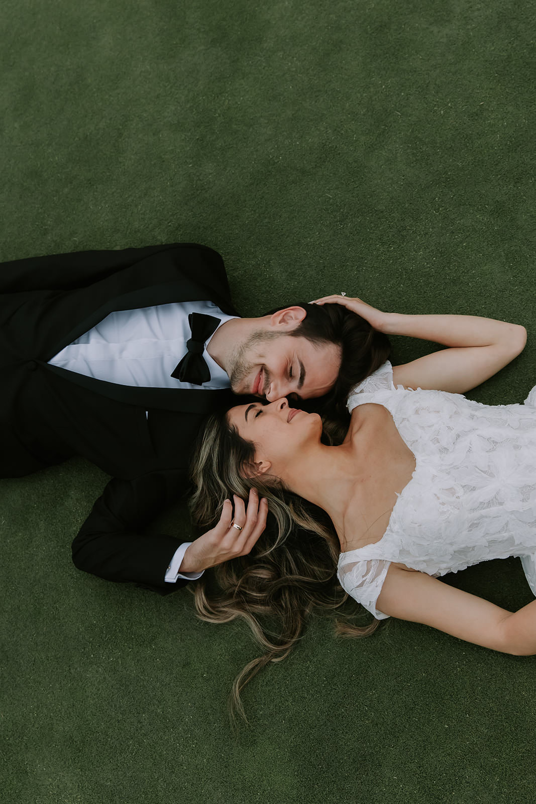 Bride and Groom laying down on the golf course at the Marbella Country Club