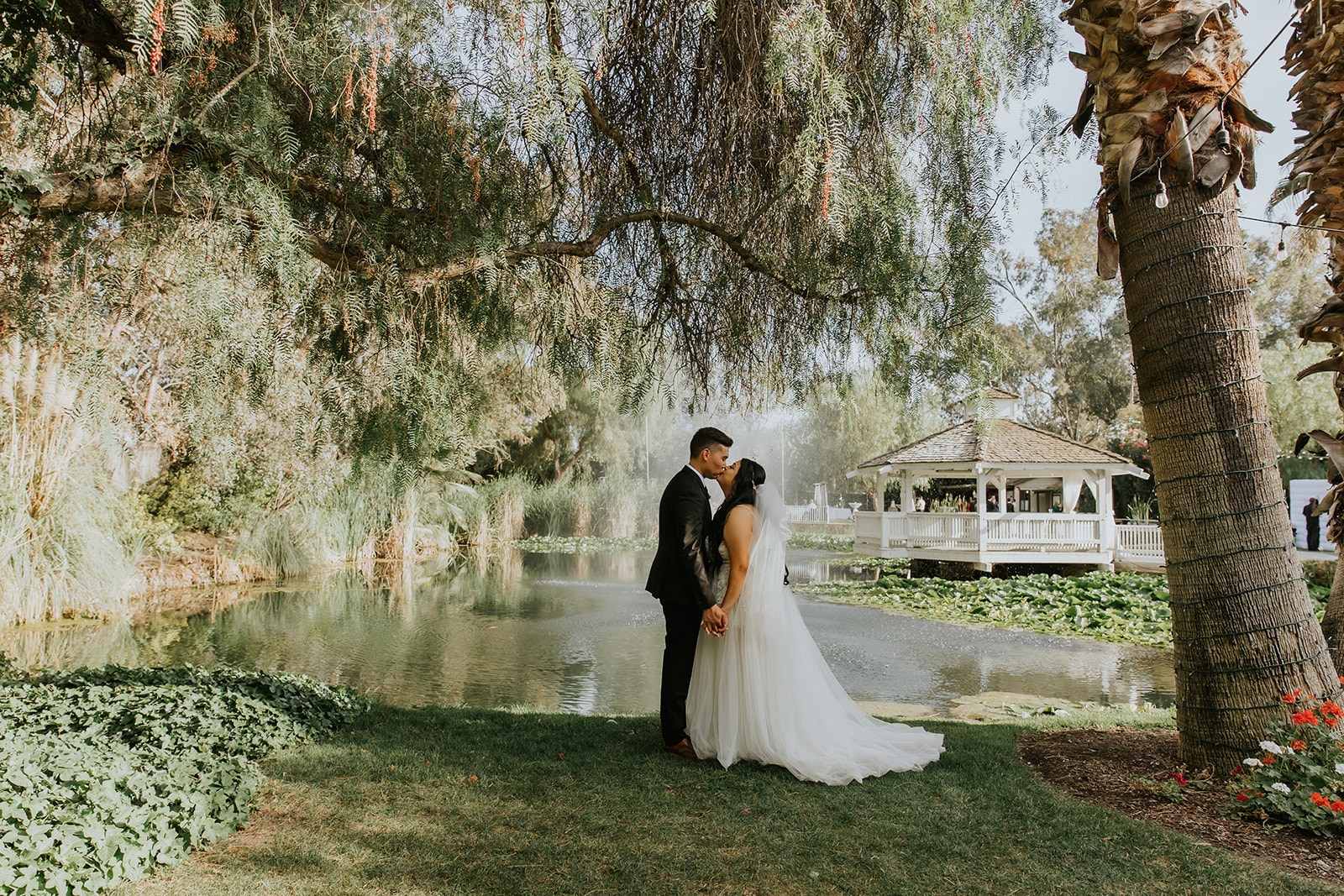 couple standing next to pond at The Orchard Wedding Venue in Menifee California