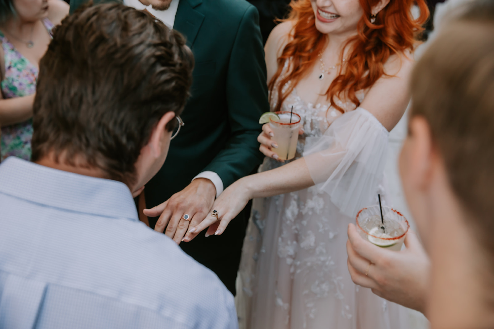bride and groom showing off their rings to their guests during cocktail hour